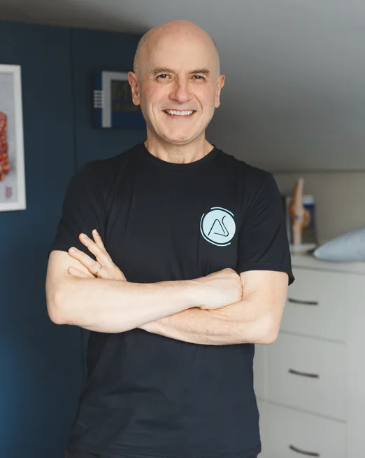 Adroaldo Santos, fisioterapeuta e osteopata, de braços cruzados no consultório
